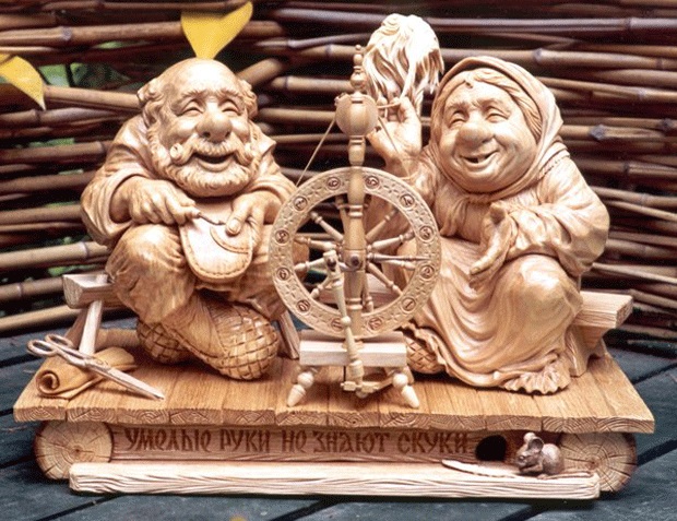wood carving couple spinning a wheel art works by mfirsanov